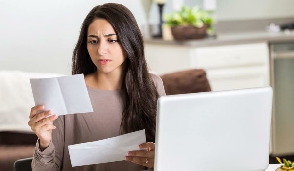 Before signing any agreements or contracts, be sure to have your attorney review them. A woman looks concerned reviewing documents.